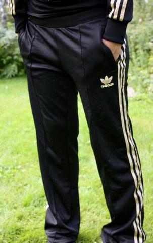 Adidas womans black shiny pants hand pocket pose front