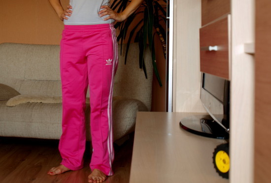 Adidas womans neon pink pants with white trim barefoot pose