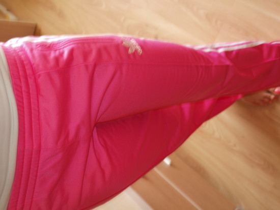 Adidas womans pink pants with white stripes sideways high angle shot