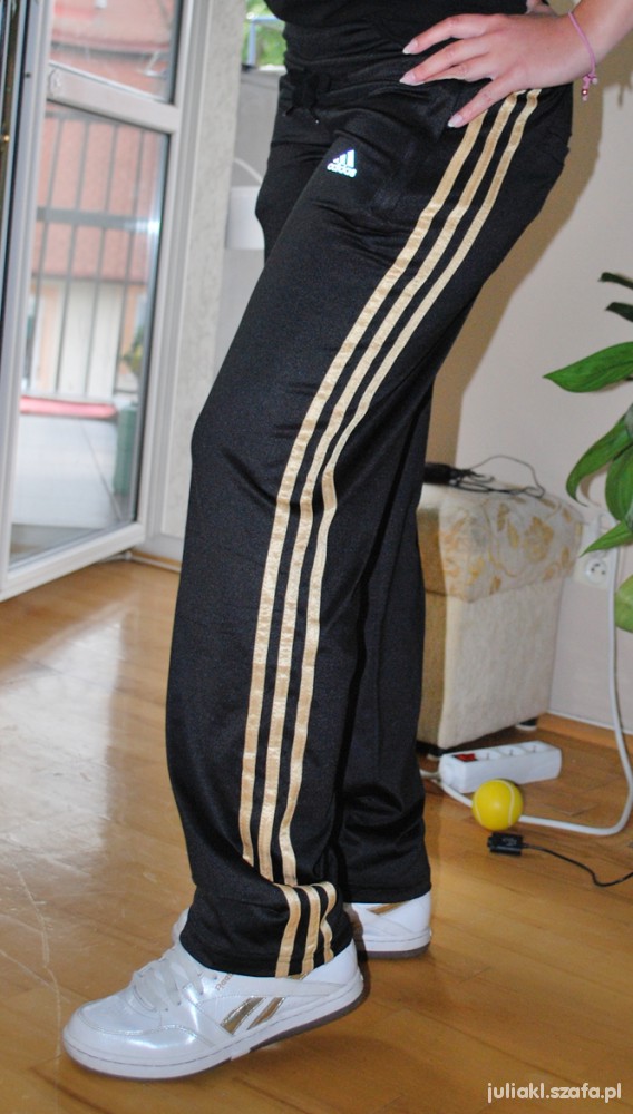 Adidas womens black pants gold stripe side leg pose