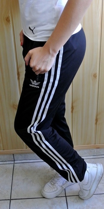 Girl in black Adidas Firebird pants