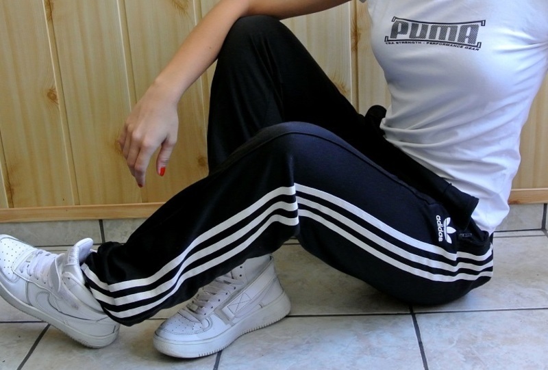 Girl in black Adidas Firebird pants