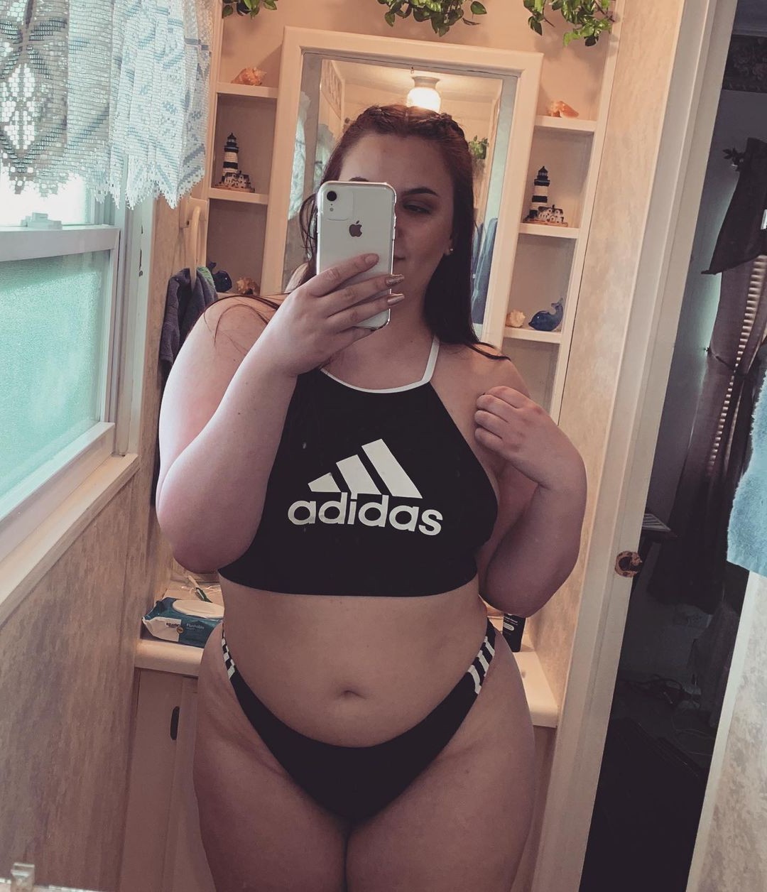 Sexy girl teasing in her adidas swimsuit Shiny Sports